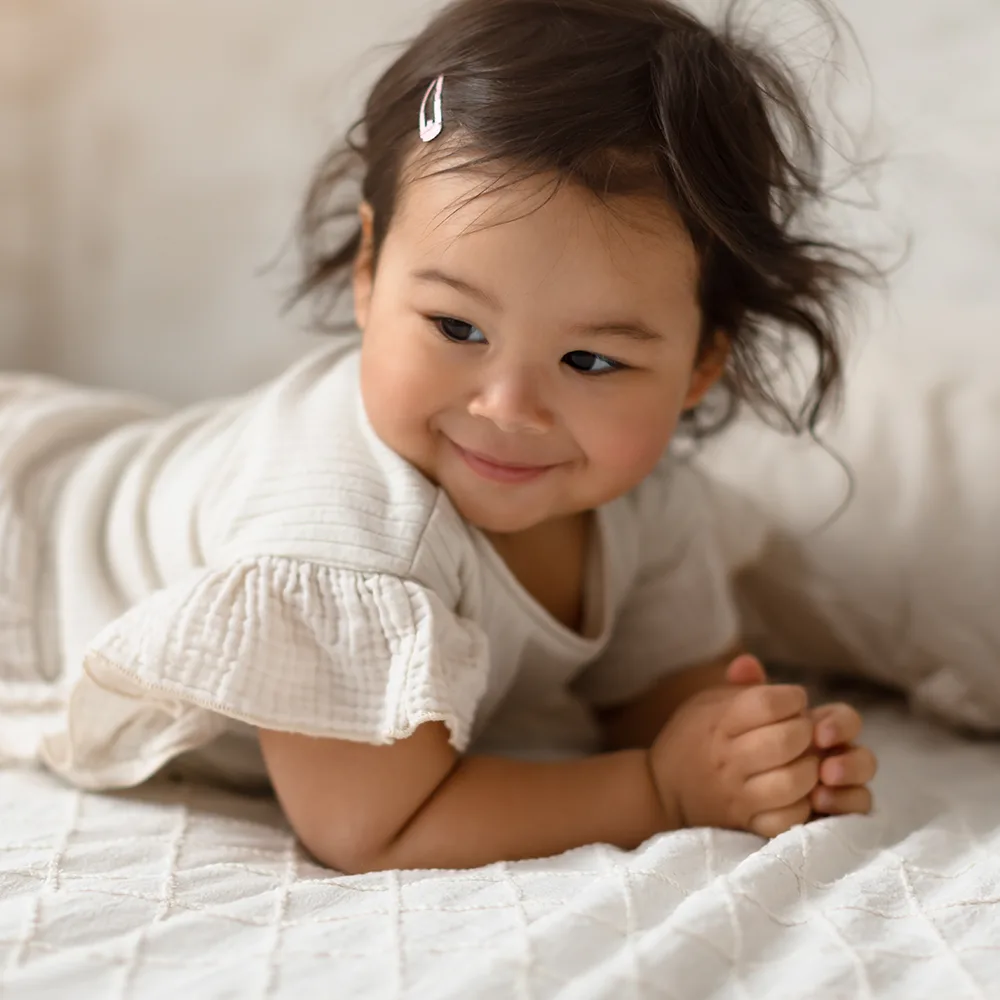 Smiling infant laying down on a couch