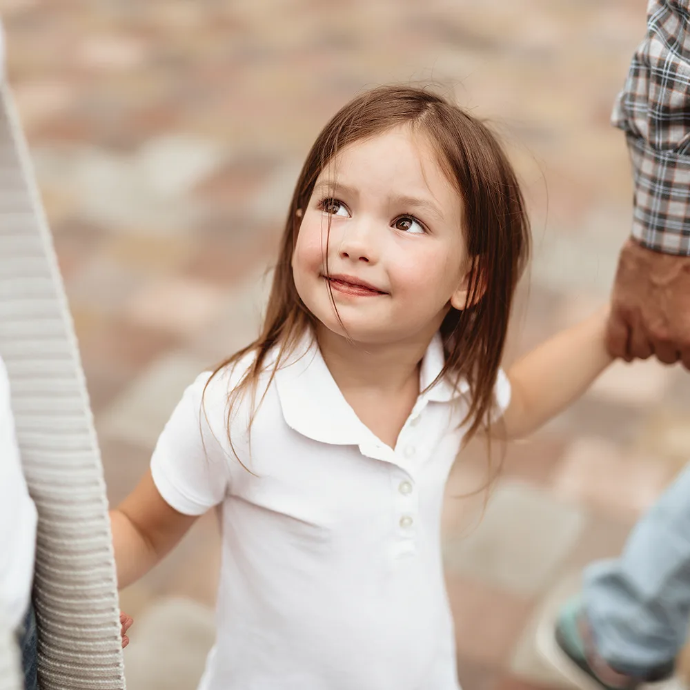 Child smiling up at mom at a Red Balloon Child Care Center daycare.