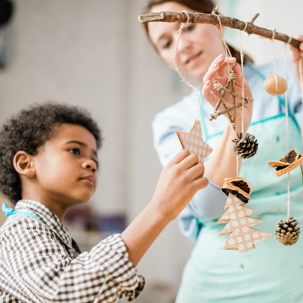 A child looking at stars hanging on string from a branch in a Red Balloon Child Care Center daycare