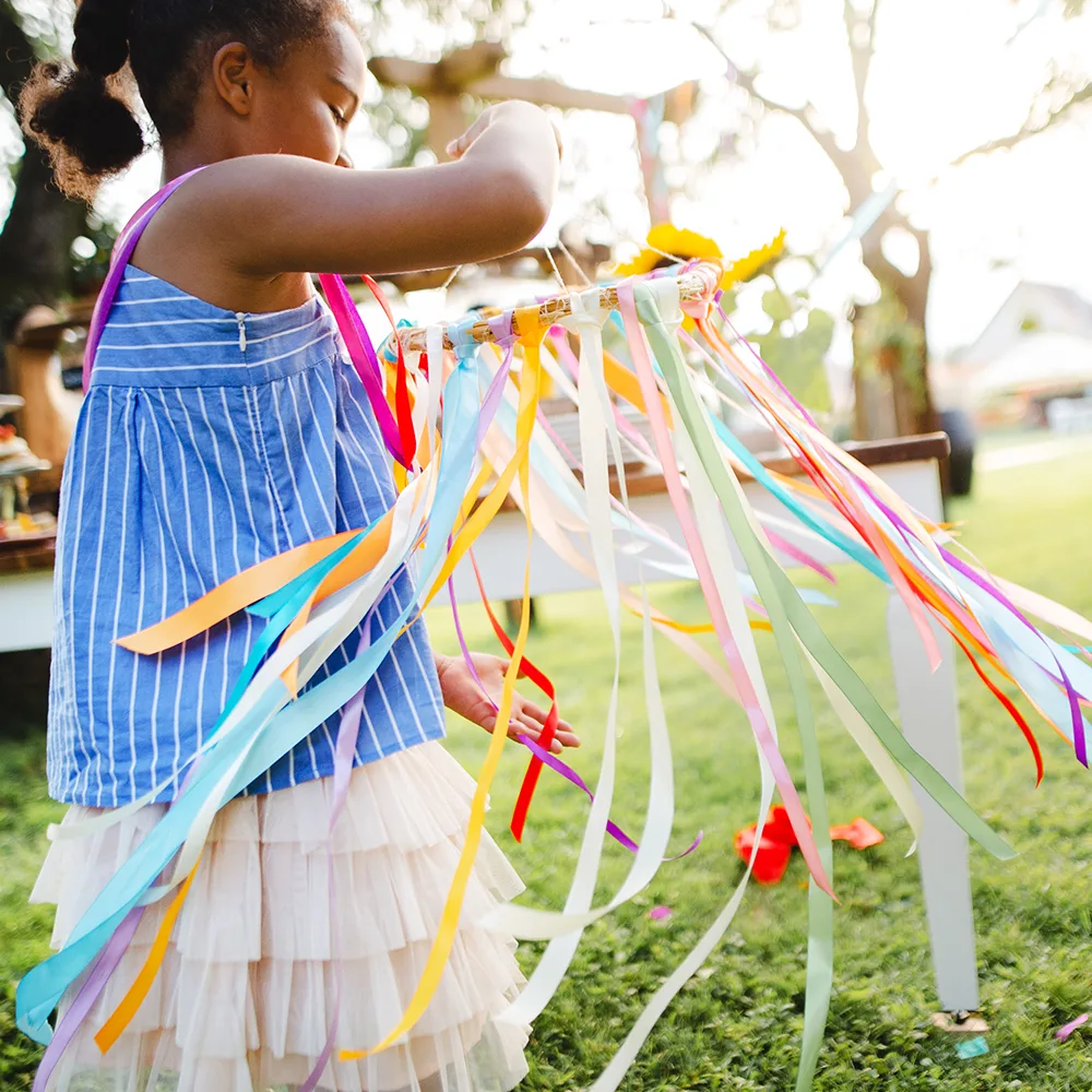 A child working on a colorful summer craft outside of a Red Balloon Child Care Center daycare