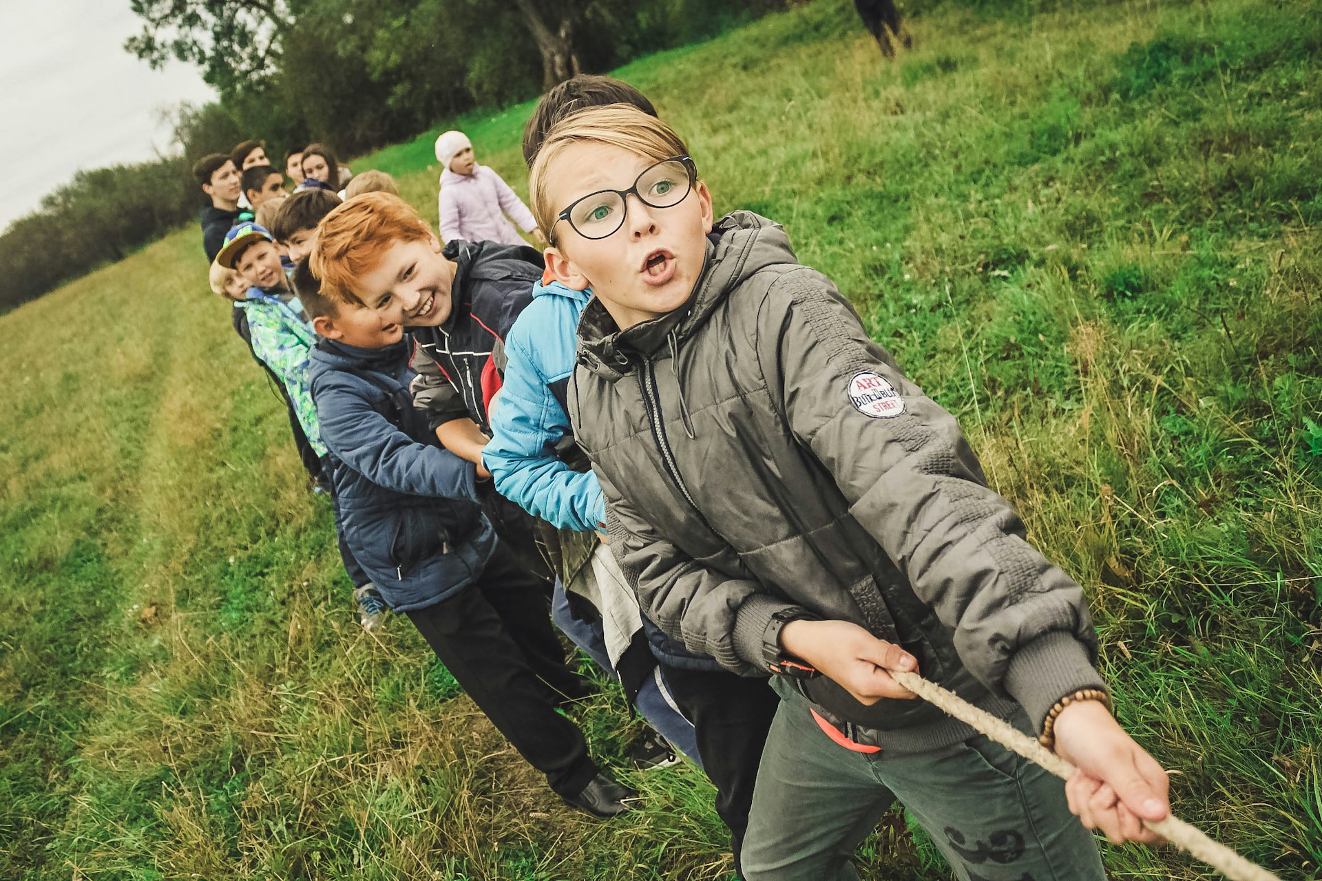 A group of kids pulling a rope outside